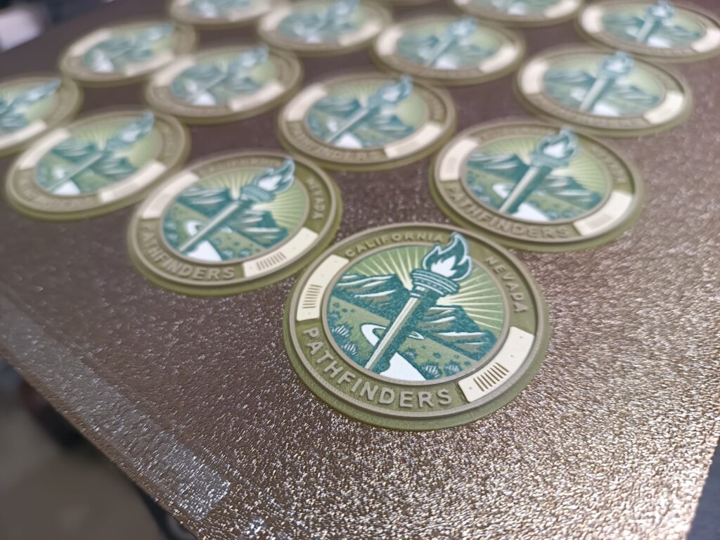 Composite design using a multi-color PLA 3d print for border elements and a dye sublimation photo for the dense center elements. Designed for the 11th Battalion, Army Reserve Careers Group